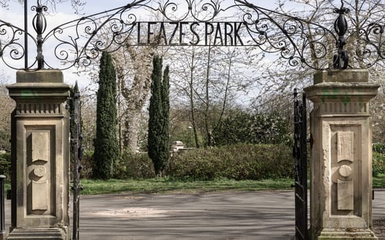 Newcastle, UK - Apr 13, 2025 - View of Cast iron lamp over the Wrought iron gate is open to the entrance of Leazes park with beautiful sky background. use it as your Wallpaper, Poster and Space for text, Selective focus.