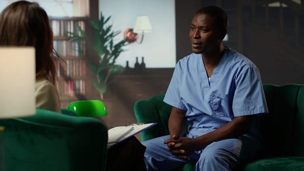 African american medical assistant in scrubs reflects on loss and burnout, sharing his feelings and anxiety based on career stress trauma. Emotional support and post traumatic healing. Camera B.