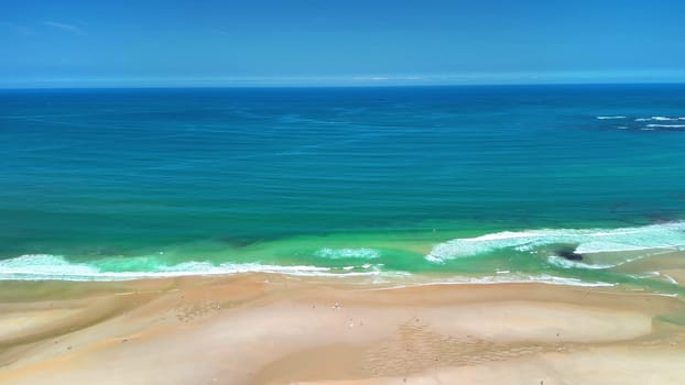 Breathtaking aerial scenery capturing the tranquil beauty of a sandy beach meeting the vibrant ocean.