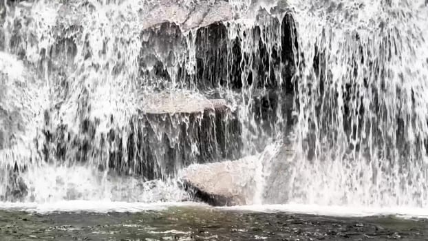 A serene and tranquil view of cascading water flowing gracefully over rocks, capturing the pure beauty of natures flow