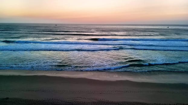 A breathtakingly captivating view of gentle ocean waves gently rolling under a picturesque sunset sky