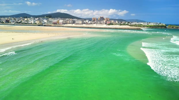 A stunning aerial shot beautifully showcasing the turquoise waters meeting the picturesque sandy shoreline