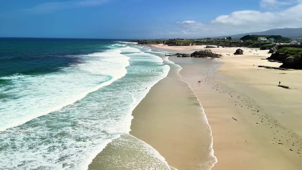 This scenic beach view features gentle waves and clear blue skies, perfect for relaxation and natures beauty