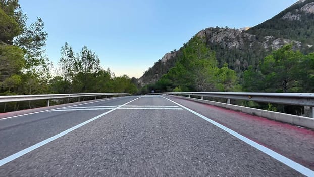 A beautiful winding road in a breathtaking mountainous landscape with vibrant trees and clear blue skies