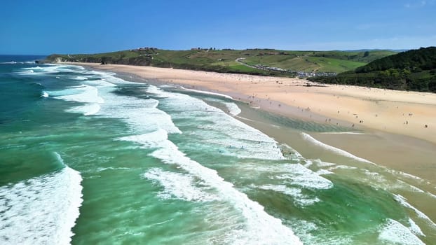 Explore this breathtaking aerial view of a beautiful beach, perfect for surfers and sunbathers alike.