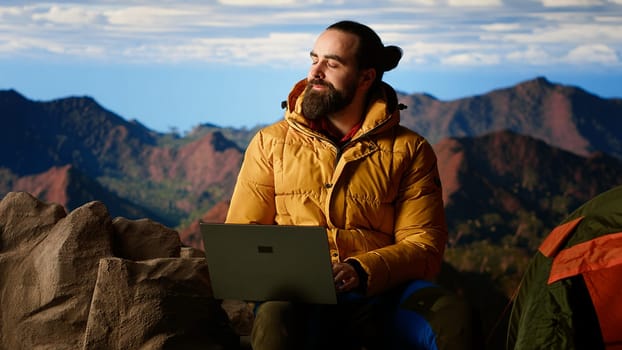 Young entrepreneur always connected to internet to do some tasks, workaholic person enjoying high speed strong signal and technology dependency. Hiker with an addiction. Camera B.