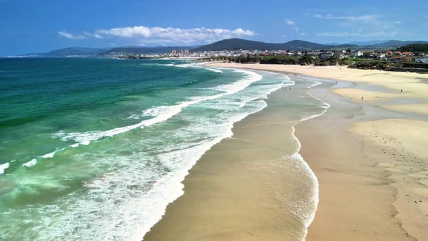 A breathtaking aerial view of a pristine beach with clear turquoise waters and gentle waves lapping the shore