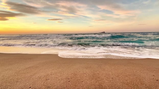 A beautifully tranquil beach scene capturing an enchanting sunset along with the gentle waves of the ocean