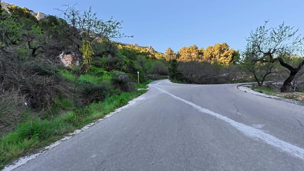 A breathtaking and picturesque view of a winding road, beautifully surrounded by lush greenery and scenic hills