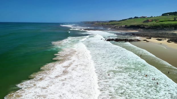 Experience the serene beauty of rolling waves meeting the shore in this breathtaking coastal landscape.