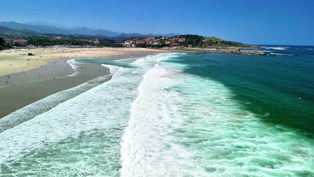 A breathtaking and stunning aerial view showcasing a vibrant, beautiful beach with inviting waves and clear, blue skies