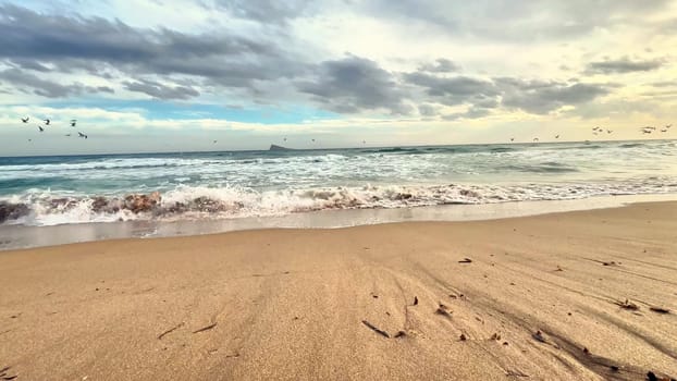 A beautifully picturesque beach scene showcasing gentle waves crashing and a moody sky, ideal for relaxation