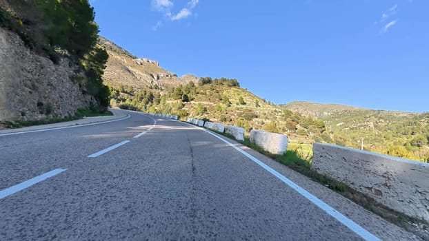 The view of the winding mountain road is absolutely breathtaking, beautifully surrounded by lush greenery all around