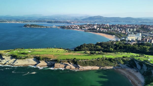 Experience a stunning aerial view of a breathtaking coastline with a beautiful golf course by the ocean