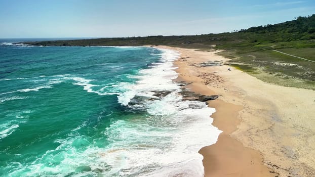 Discover a pristine beach with turquoise waves and golden sands in this breathtaking aerial photograph