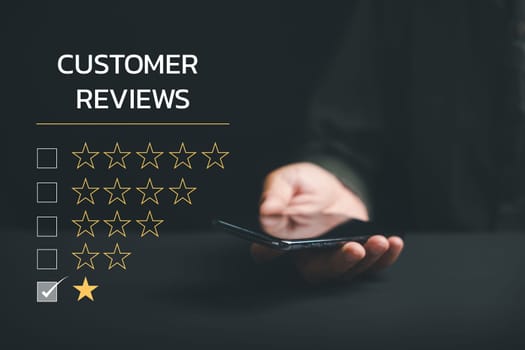 Expressing dissatisfaction through a 1-star satisfaction rating on social media using a smartphone. Negative feedback concept impacting business reputation and customer opinion.