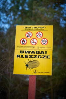 Swinoujscie, Poland – December 22, 2024: Sign on the Polish Baltic coast with the inscription Uwaga Kleszcze. Translation: attention ticks