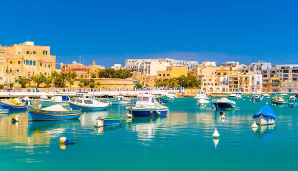 Beautiful cityscape of Birzebbuga with fishing boats lying on the water, Malta.