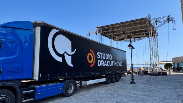 Budva, Montenegro - May 18, 2025: Studio Dragutinovic truck is parked near the stage being set up for Montenegro's Independence Day.