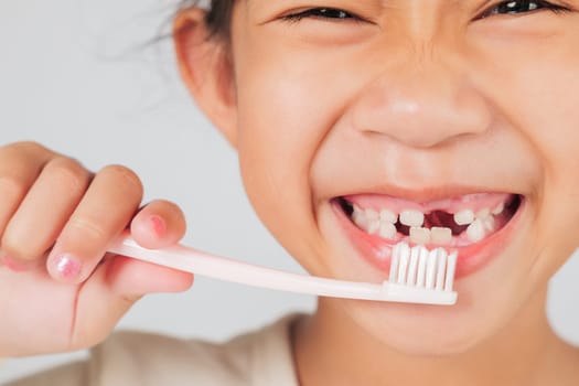 Cheerful kid brushes teeth, revealing a tooth gap. The dentist shares tips on tooth loss and caring for a tooth gap to ensure strong teeth growth. isolated white background