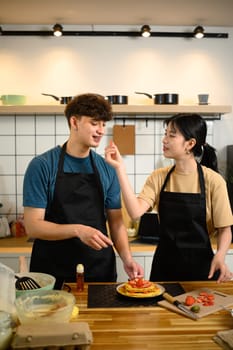 Young couple enjoying cooking together and creating a beautifully plated breakfast.