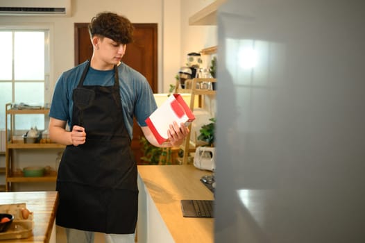 Caucasian man examining a food product before starting preparation.