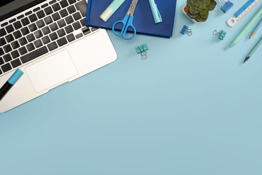 Top view of creative workspace with laptop office supplies.