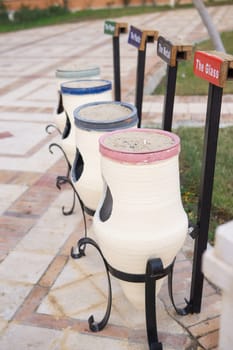 White ceramic outdoor recycling bins specifically for sorting paper plastic metal glass. Environmental waste management concept for public areas and hotels seeking sustainability