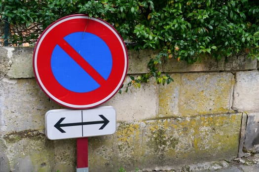 A no parking sign is on a wall next to a sign that says "left" and "right".