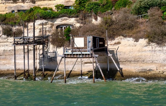 the traditional fisherman's wooden hut at the bottom of the limestone cliff in the estuary of Gironde, Meschers-sur-Gironde