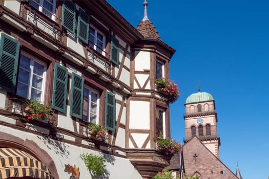 A building with a clock tower and a green dome. The building has a lot of windows and a balcony
