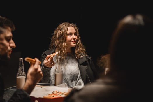 A group of friends shares a joyful moment, celebrating friendship over pizza and drinks. The atmosphere is relaxed, highlighting camaraderie and good food in a cozy environment.