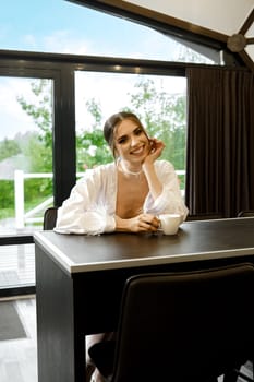 Relaxed happy woman enjoying coffee in modern bungalow in the morning
