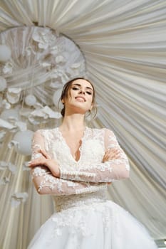 Beautiful bride posing with folded arms, low angle view