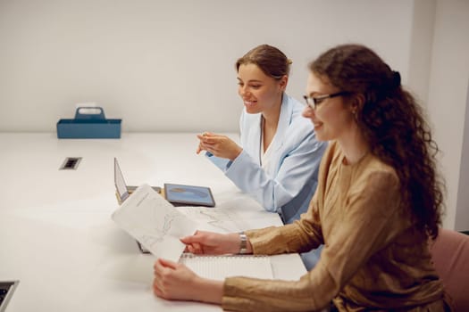 In a stylish meeting room, two women are engaged in a highly productive and insightful work discussion