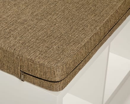 Removable beige fabric cushion cover with zipper on a modern white bench, perfect for adding comfort and style