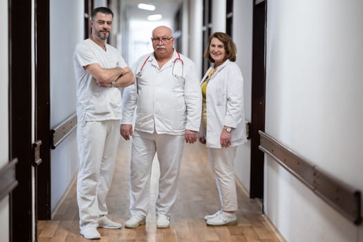 A team of experienced doctors standing in the hospital hallway, weary but dedicated after a long day of caring for patients