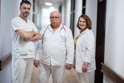 A team of experienced doctors standing in the hospital hallway, weary but dedicated after a long day of caring for patients