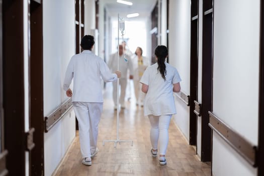 Medical personnel, including doctors and nurses, urgently respond in a busy hospital hallway, showcasing their quick action and teamwork in a critical situation