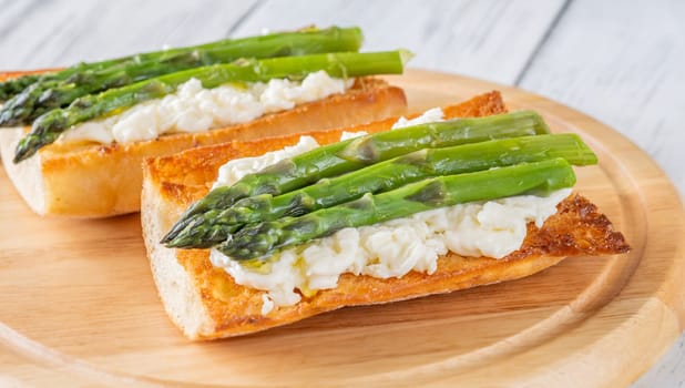 Toasted ciabatta holds creamy cheese and asparagus glistening in golden oil
