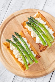 Toasted ciabatta holds creamy cheese and asparagus glistening in golden oil