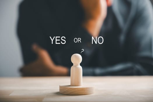 Wooden cube with peg dolls, yes or no choices in business. Man's hand holds two options emphasizing decision-making. Red question mark reinforces the concept. Think With Yes Or No Choice.