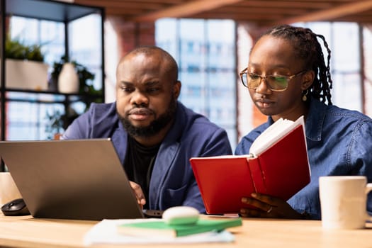 African american couple work on a management project for freelancing, using a laptop to research business trends and manage an online brand. Successful remote career development.