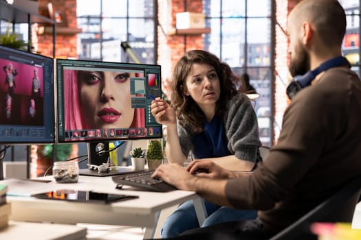 Professional photo editor interacts with AI chatbot and retouching software on dual monitors, using machine learning tools to generate high quality images. Photography industry with automation.