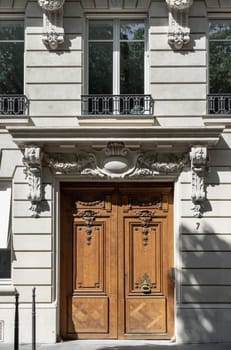 France, Paris - May 03, 2025 - Magnificent entrance facade brown door in Paris. Old architecture splendour of Vintage wood doorway, use it as your Wallpaper, Poster and Space for text, Selective focus.