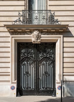 France, Paris - May 03, 2025 - Gorgeous Parisian doorway with intricate wrought iron gates and ornate stonework wall, Classic french architecture entrance facade door in Paris. use it as your Wallpaper, Poster and Space for text, Selective focus.