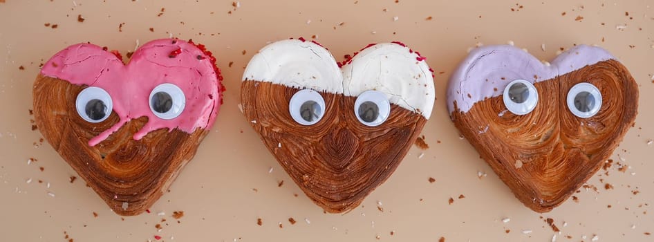 Funny food game face with crazy eyes April fool day joke Delightful and vibrant heartshaped pastry croissant treat, beautifully topped with colorful frosting galore. Copy space. Food experimentation viral dessert creative baking trend