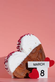 8 March international women's day Heart shaped white chocolate croissant on pink background with copy space. Puff pastry new trendy sweet dessert bakery. Creamy dough experiment