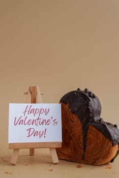 Happy Valentine's Day saying caption on greeting card Delightful and vibrant heartshaped pastry croissant treat, beautifully topped with colorful frosting galore. Copy space. Food experimentation viral dessert creative baking trend