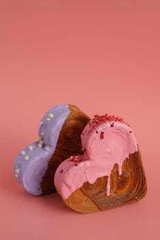 Heart shaped two couple croissants on pink background with copy space. Puff pastry new trendy sweet dessert bakery. Creamy dough experiment